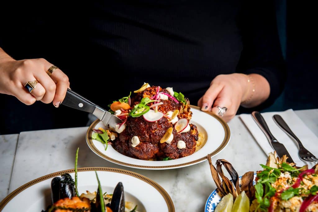 Guest digging into Bar Sofia's whole cauliflower