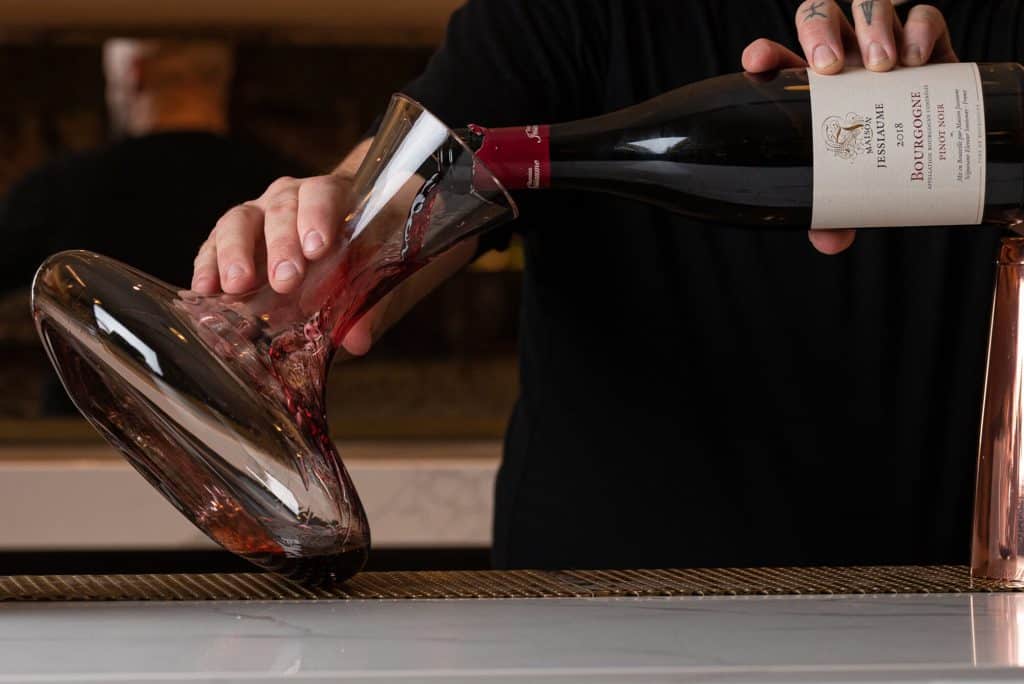 Red wine being poured into a decanter at Cafe Lunette