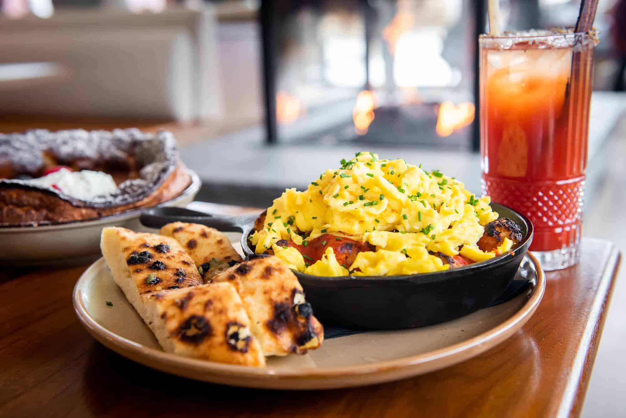 Salt + Ash tate tot skillet sitting on a wood top table in front of a fireplace