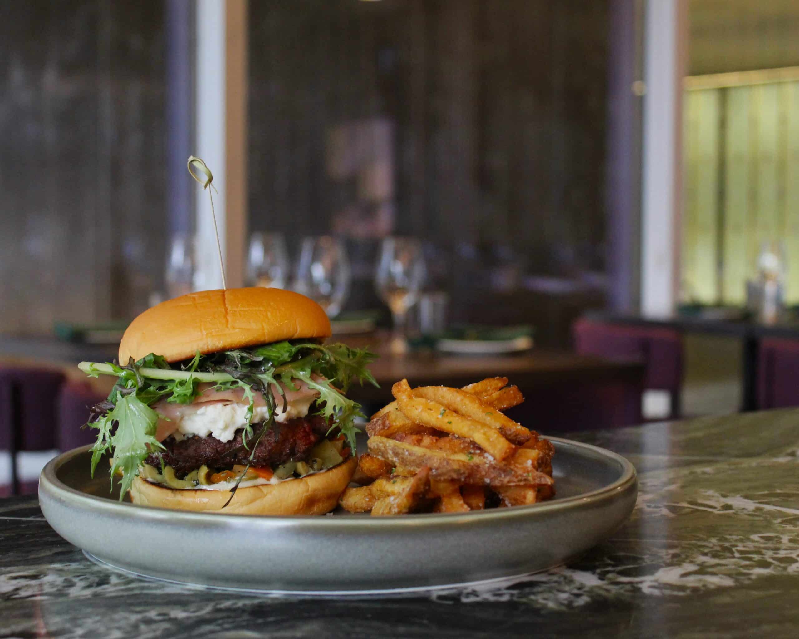 burger and fries sitting on a champagne bar